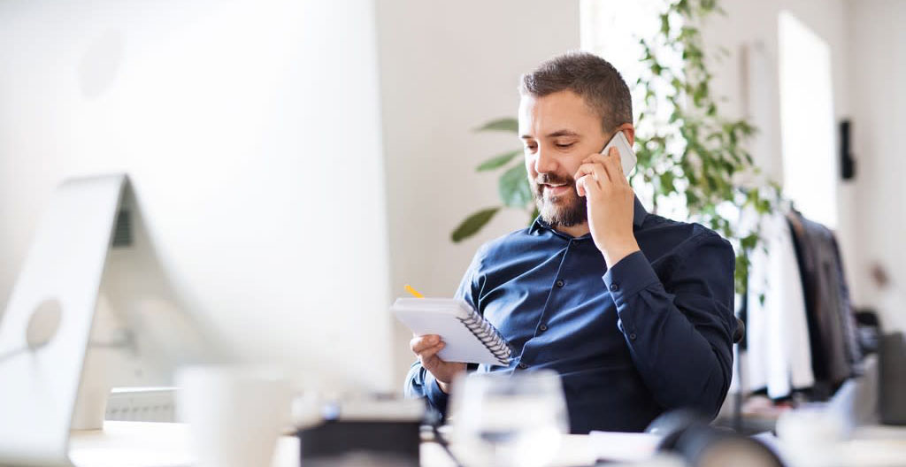 Deux personnes vues de dos consultant ensemble une tablette numérique dans un salon contemporain lumineux, ambiance décontractée